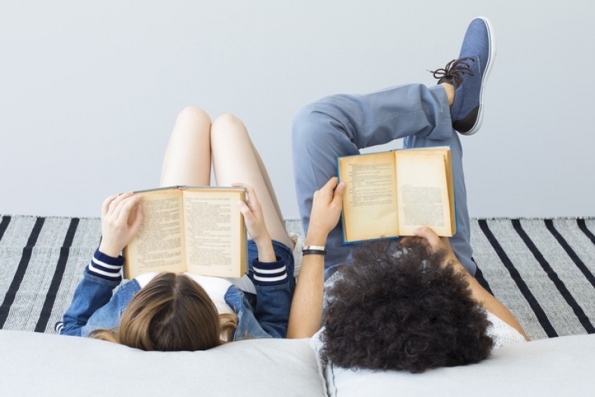 en gutt og en jente ligger og leser hver sin bok, de er vendt vekk fra oss slik at vi kun set bakhodet og hva de leser